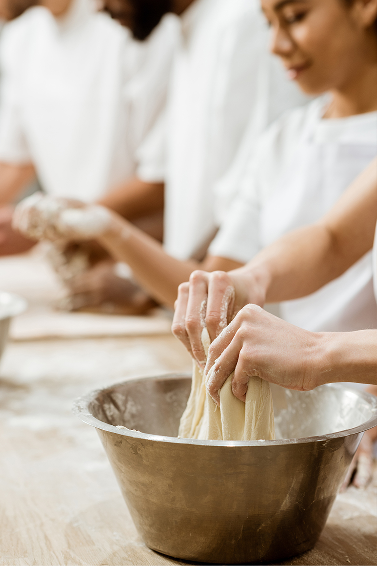 Kids learning how to cook in a cooking class.